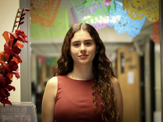 Picture of Ana standing in front of a colorful banner