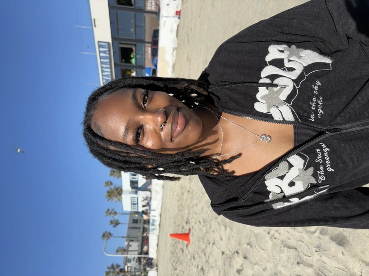 girl with dreads smiling at the beach